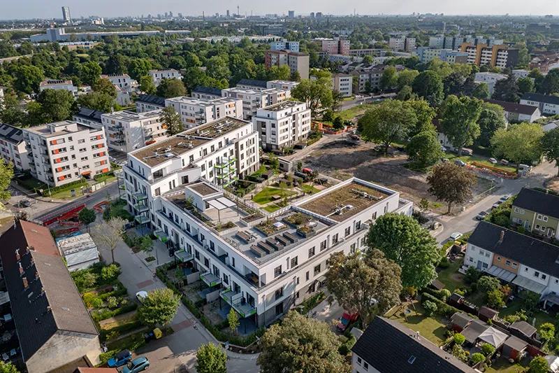 Luftaufnahme eines modernen Wohnquartiers mit begrünten Innenhöfen